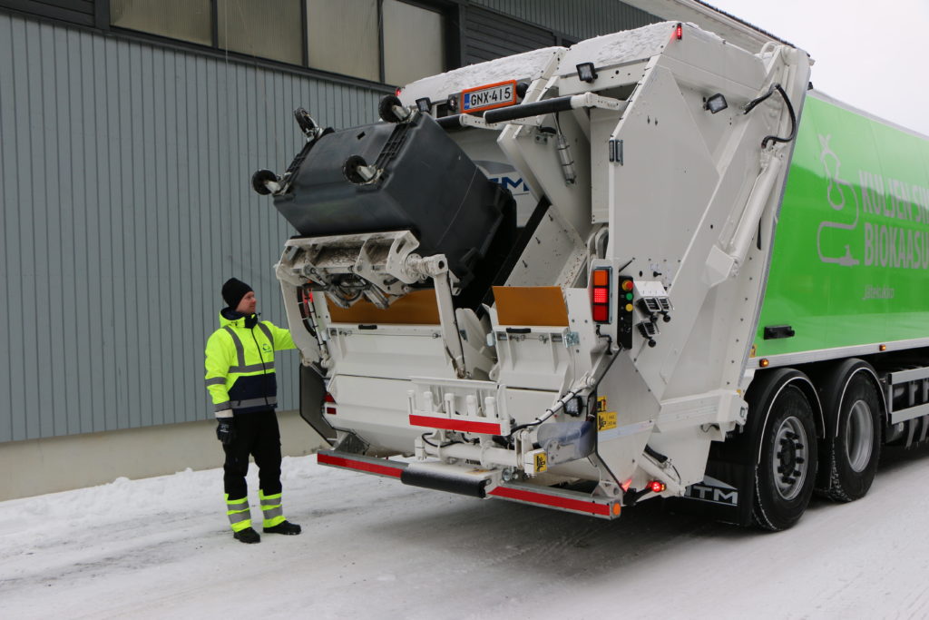 Kaksilokeropakkaajalla voidaan kerätä kahta jaetta samalla ajolla. NTM on Pohjoismaiden suurin jätepakkaajien valmista. Kuljettaja Tomi Tuonanen antaa näytteen työvaiheesta, joka tehdään kymmeniä kertoja päivässä.